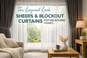 A bright Melbourne living room featuring layered sheer and blockout curtains installed on a double track system, demonstrating how combining light-filtering sheers with thermal blockouts provides year-round climate control, privacy, and elegant interior styling.